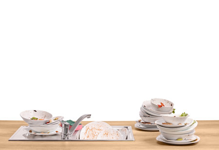 Greasy and dirty dishes in a sink on a wooden counterの写真素材