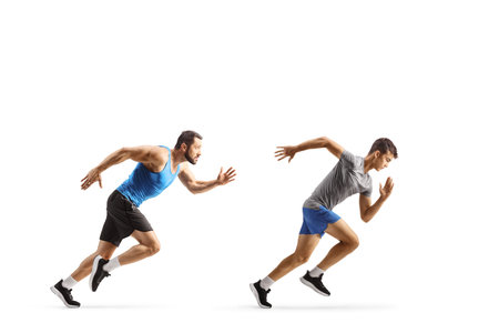 Full length profile shot of a fit male athletes running fast isolated on white background