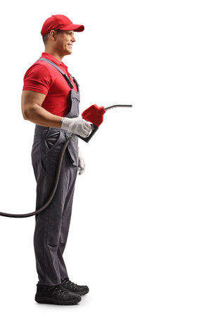 Full length profile shot of a gas station worker holding a refuel petrol gun isolated on white backgroundの写真素材