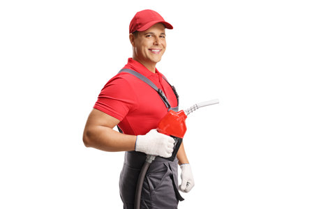 Gas station worker holding a petrol refueling gun and smiling isolated on white backgroundの写真素材