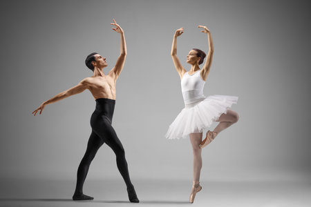 Man and woman dancing professional ballet isolated on gray backgroundの写真素材