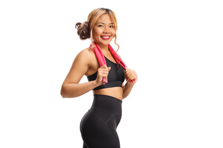 Fit young woman in sportswear holding a towel isolated on white backgroundの写真素材