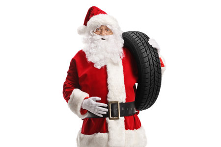 Santa claus carrying a car tire on his shoulder isolated on white backgroundの写真素材