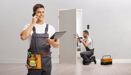 Team of repairmen fixng a door in an apartmentの写真素材