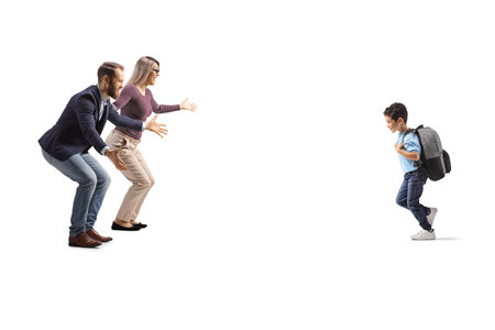 Full length profile shot of a schoolboy running towards his parents isolated on white backgroundの写真素材