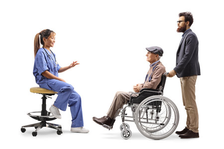 Female asian doctor talking to a patient in a wheelchair isolated on white backgroundの写真素材