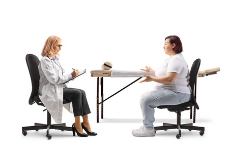 Female doctor writing a prescription for a woman isolated on white backgroundの写真素材