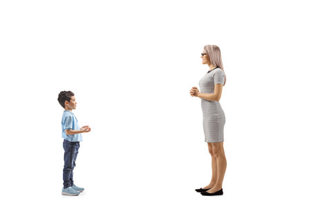Full length profile shot of a boy talking to a woman isolated on white backgroundの写真素材