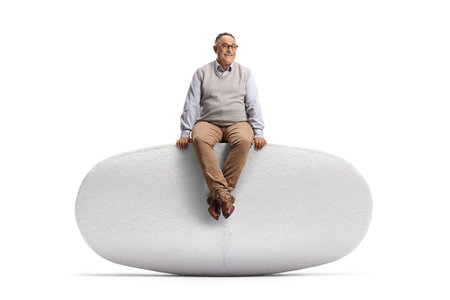 Mature man sitting on a big pill isolated on white backgroundの写真素材