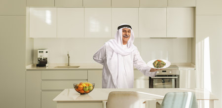 Man holding a plate with arabic salad tabule in a kitchenの写真素材
