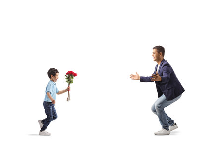 Boy running and giving a bouquet of red roses to his father isolated on white backgroundの写真素材
