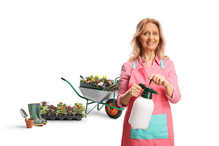 Female gardener holding a bottle spray for plants isolated on white backgroundの写真素材