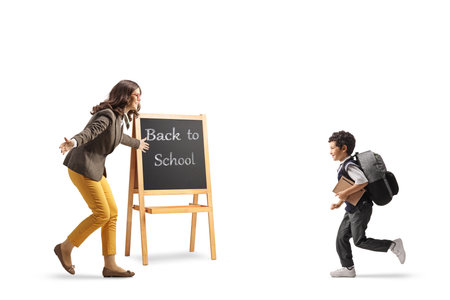 Boy running to meet his teacher at school isolated on white backgroundの写真素材