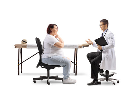 Overweight woman talking to a male physician isolated on white backgroundの写真素材