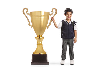 Schoolboy in a uniform winning a big trophy cup isolated on white backgroundの写真素材