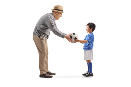 Elderly man giving a football to a kid isolated on white backgroundの写真素材