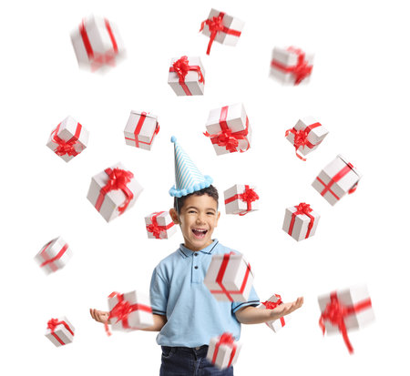 Birthday boy with a party hat and presents flying in the air isolated on white backgroundの写真素材