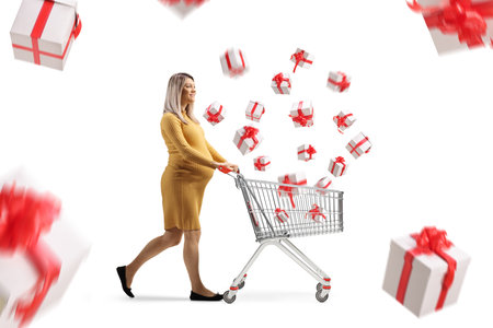 Pregnant woman with a shopping cart and falling presents isolated on white backgroundの写真素材