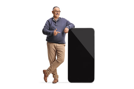 Mature man pointing at a big smartphone with empty black screen isolated on white backgroundの写真素材