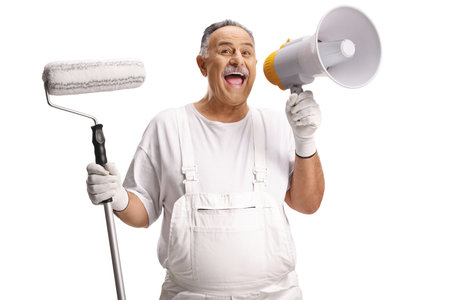 Cheerful painter holding a paint roller and a megaphone isolated on white backgroundの写真素材