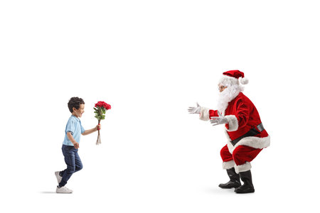 Full length profile shot of a boy giving flowers to Santa Claus isolated on white backgroundの写真素材