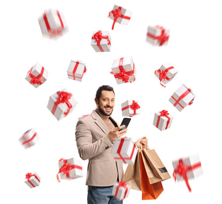 Man with a smartphone, shopping bags and presents isolated on white backgroundの写真素材