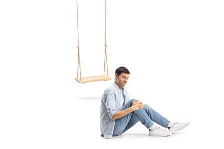Man falling from a wooden swing and injuring knee isolated on white backgroundの写真素材