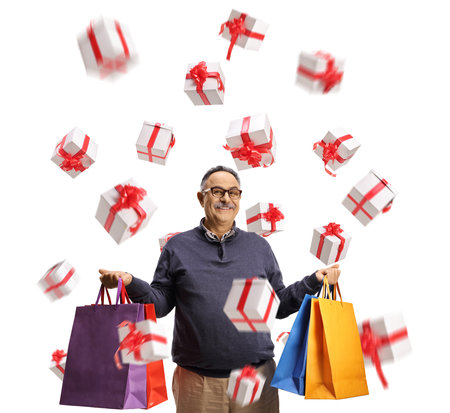Mature man with shopping bags and presents flying in the air isolated on white backgroundの写真素材