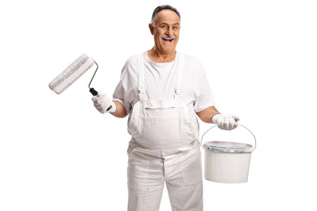 Mature male painter holding a bucket and paint roller isolated on white backgroundの写真素材