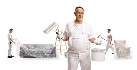 Team of painters getting ready for work and putting drop cloth on furniture isolated on white backgroundの写真素材