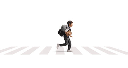 Schoolboy running on a street at a zebra crossing isolated on white backgroundの写真素材