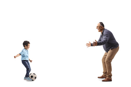 Little boy playing football with a mature man isolated on white backgroundの写真素材