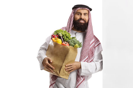 Middle eastern man with a grocery bag isolated on white backgroundの写真素材