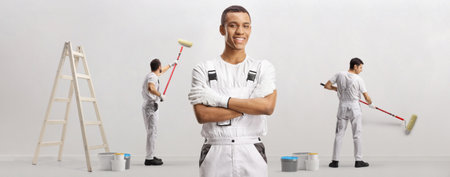 African american painter working with a team and painting a wallの写真素材