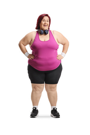 Full length portrait of a plus size woman in sportswear with headphones isolated on white backgroundの写真素材