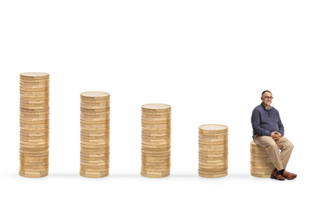 Mature man seated on a pile of coins isolated on white backgroundの写真素材