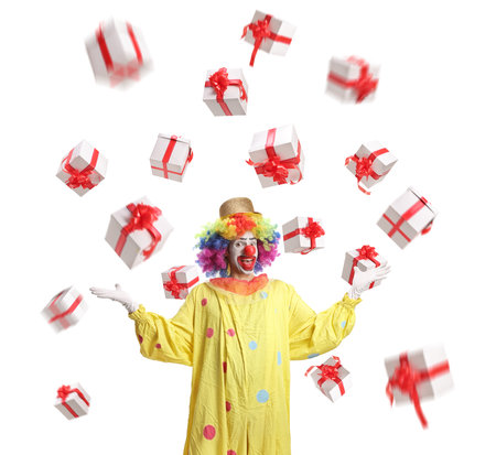 Clown standing under falling presents isolated on white backgroundの写真素材