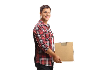 Young man carrying a cardboard box and smiling isolated on white backgroundの写真素材