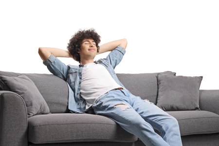 Relaxed young man enjoying on a sofa isolated on white backgroundの写真素材