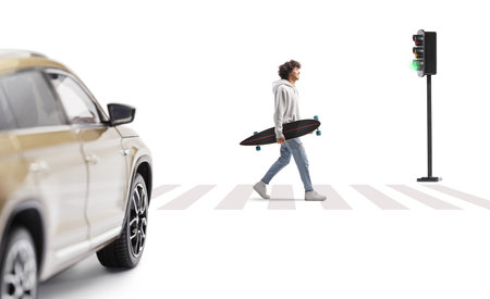 Guy with a longboard crossing a street at green traffic light isolated on white backgroundの写真素材