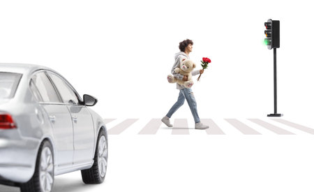 Full length profile shot of a guy on a street with a teddy bear and red rosesの写真素材