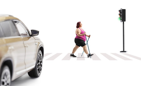 Woman walking with hiking poles at a zebra crossing isolated on white backgroundの写真素材