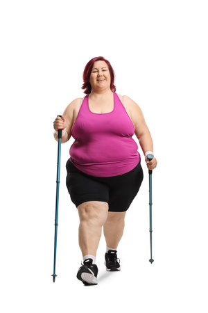 Overweight woman walking with hiking poles isolated on white backgroundの写真素材