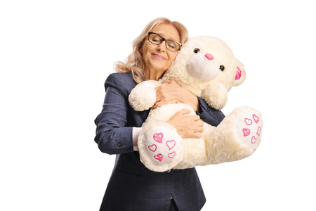 Happy mature woman hugging a teddy bear isolated on white backgroundの写真素材
