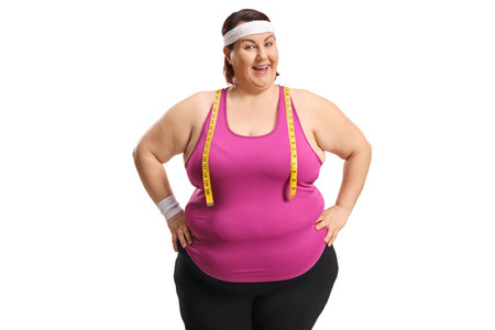 Overweight woman with a measure tape smiling at camera isolated on white backgroundの写真素材