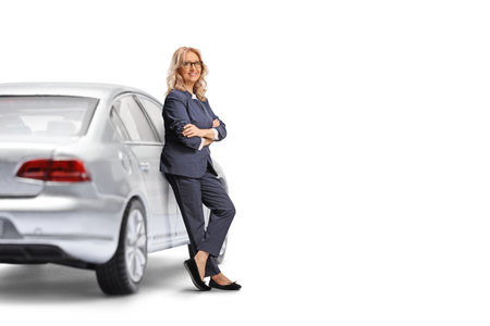 Woman driver leaning on a car isolated on white backgroundの写真素材
