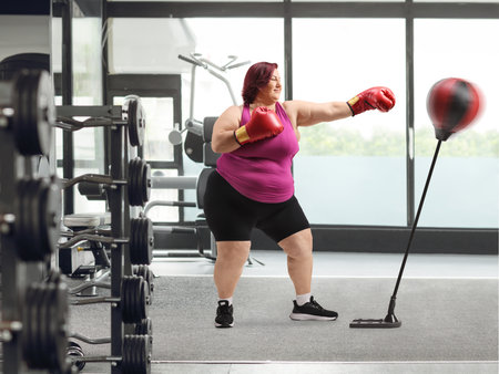 Woman training box at a gym with a punch stand, weight loss conceptの写真素材