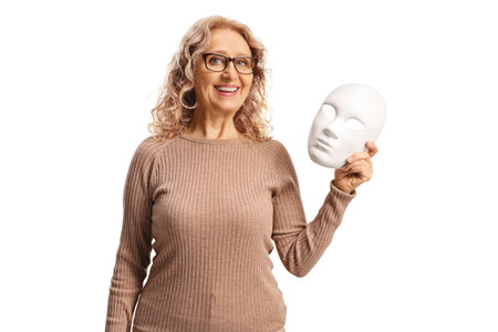 Woman holding a white mask and smiling isolated on white backgroundの写真素材