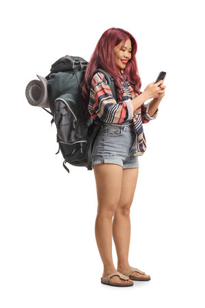 Female backpacker using a smartphone isolated on white backgroundの写真素材