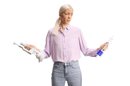 Confused woman holding toilet tank parts isolated on white backgroundの写真素材